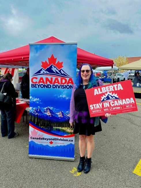Community member holding a Stay in Canada lawn sign