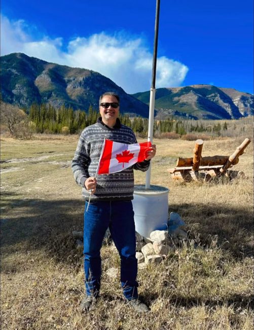 Campaign volunteer with a Canadian flag in the mountains